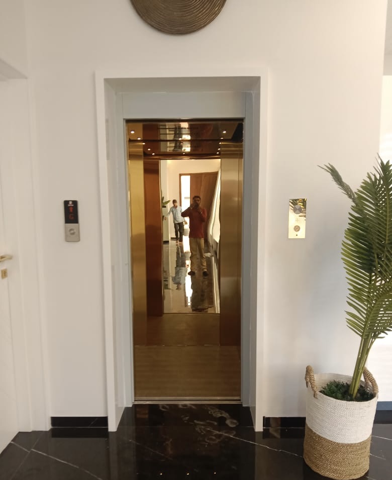 Golden elevator interior with reflective surfaces